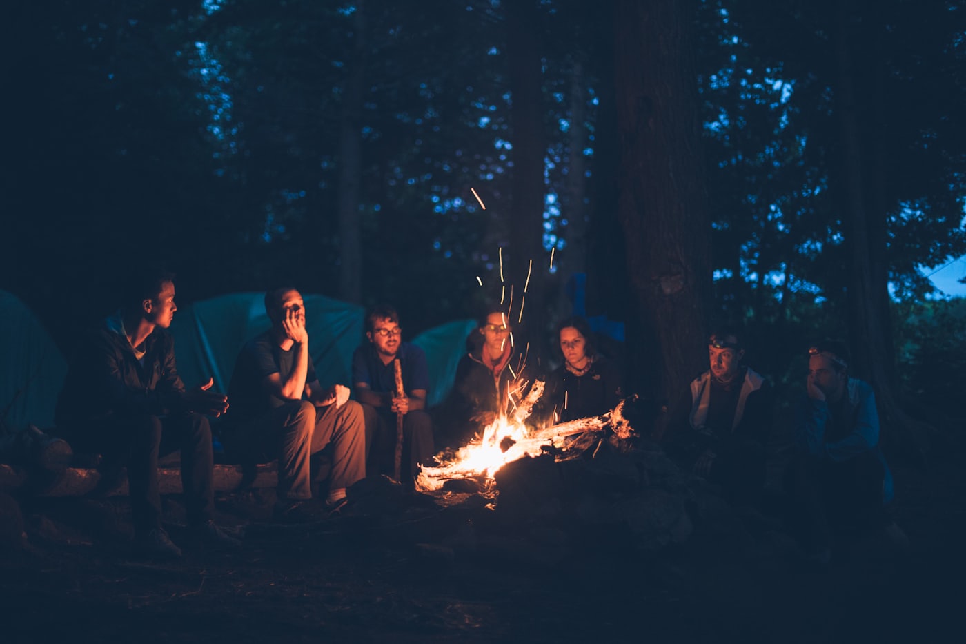 Friends gathered around a campfire in the evening